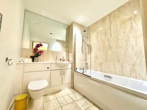 een badkamer met toilet, bad en wastafel bij VIPAbodes at Woking Central in Woking +24 foto's