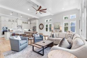 a living room with a couch and chairs and a kitchen at Sunset Key in Inlet Beach