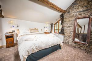 una camera da letto con un letto grande e un muro di pietra di Self Catering Accommodation, Cornerstones, 16th Century Luxury House overlooking the River a Llangollen