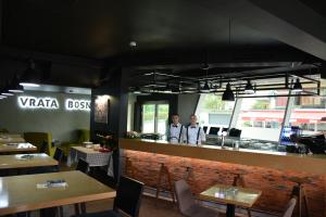 two people standing at the counter of a restaurant at Hotel Vrata Bosne in Velika Kladuša