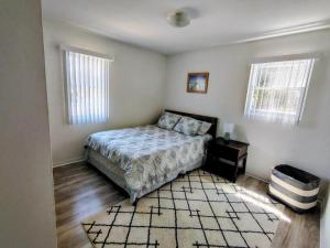 a bedroom with a bed and two windows and a rug at Seagull`s Rest in Navarre