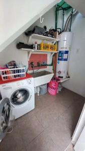 eine Waschküche mit einem Waschbecken und einer Waschmaschine in der Unterkunft Hosteria TDT in Mar del Plata + 2 Fotos