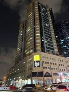 ein großes Gebäude, vor dem Autos parken in der Unterkunft Ajman Rashdiya 1 in Ajman 