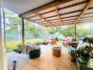 a wooden deck with chairs and a pergola at Blue Horizon, Couple's GC Hinterland retreat in Tallebudgera +28 photos