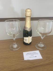 een fles wijn en twee glazen op een tafel bij Paraíso das Flores Suíte Confort in Socorro