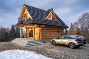 a tiny house with a car parked in front of it at Drewniane Zacisze in Biały Dunajec