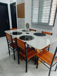 a dining room table with chairs and a white table at Résidence meuble in Abidjan