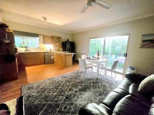 ein Wohnzimmer mit Tisch und Küche in der Unterkunft Blue Horizon, Couple's GC Hinterland retreat in Tallebudgera