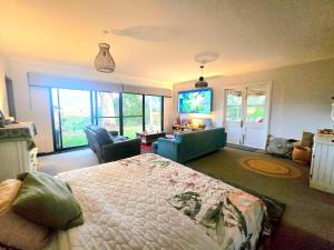 ein Schlafzimmer mit Bett und ein Wohnzimmer in der Unterkunft Blue Horizon, Couple's GC Hinterland retreat in Tallebudgera