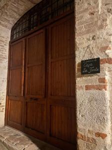 a pair of wooden doors on a stone wall at Casa "La Fonte" in Spoleto
