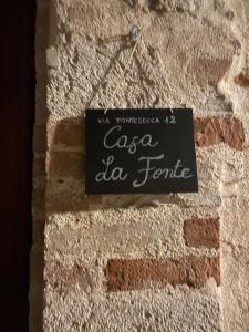 a sign on the side of a brick wall at Casa "La Fonte" in Spoleto