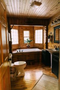 a bathroom with a tub and a toilet and a sink at Creekside Oasis! in Stanton +103 photos