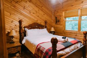 a bedroom with a bed in a log cabin at Creekside Oasis! in Stanton