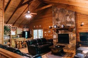 a living room with leather furniture and a stone wall at Creekside Oasis! in Stanton