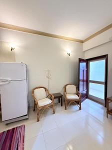 a living room with two chairs and a refrigerator at Kabeel's House in Dahab