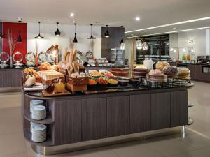 a buffet line with many different types of pastries at Ibis Bangkok Riverside in Bangkok