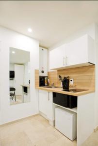 a kitchen with white walls and wooden countertops at Paris sud studio cosy in Arcueil