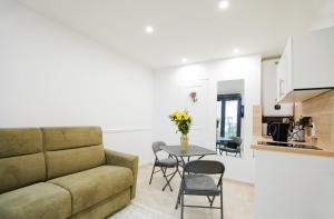 a living room with a couch and a table with chairs at Paris sud studio cosy in Arcueil