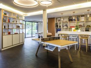 una sala da pranzo con tavolo da ping pong e sedie di ibis Genève Petit Lancy a Ginevra