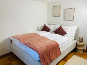 a bedroom with a bed with white sheets and pillows at Cara Nima Schwyz in Schwyz