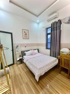 ein Schlafzimmer mit einem Bett und einem Fenster in der Unterkunft Naomi House Phan Thiet in Phan Thiet