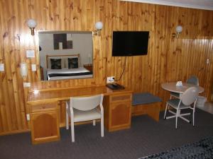 a room with a desk and a mirror and a bed at Blue Diamond Motor Inn in Dubbo