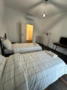 a bedroom with two beds and a table with a laptop at Dante appartamento 1 in Fagnano Olona