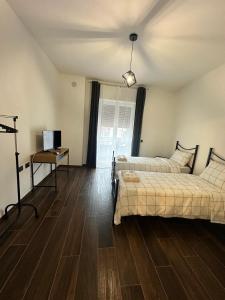 a bedroom with two beds and a table and a television at Dante appartamento 1 in Fagnano Olona