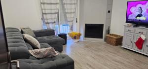 un soggiorno con un divano e una TV di O Cantinho da Avó ad Azeitao