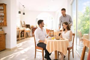a group of people sitting at a table in a restaurant at Hotel Comfort Erica Dolomiti Val d'Adige in Salorno