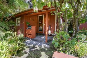a small wooden house with a porch at Volcano Artist Cottage in Volcano