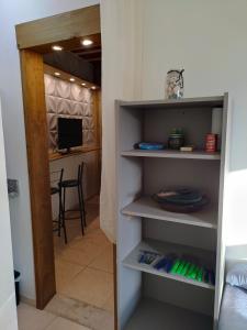 a room with a book shelf with a dining room at Kitnet no Morro dos Conventos in Araranguá