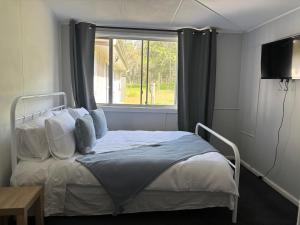 un letto in una stanza con una finestra di Coastal Escape a Kempsey