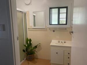 un bagno bianco con un lavandino e una finestra di Coastal Escape a Kempsey Altre 69 foto