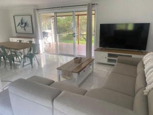 un soggiorno con divano e TV a schermo piatto di Coastal Escape a Kempsey