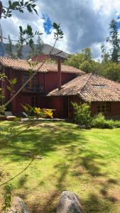 a house with a grass yard in front of it at Casa Munay in Urubamba