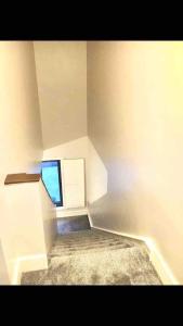 Cette chambre blanche dispose d'un escalier et d'une fenêtre. dans l'établissement Shangri-La Spacious Family Townhouse large free carpark, à Killarney