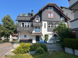 een huis met een blauwe auto die ervoor geparkeerd staat bij Strömbergs Gunnar in Oberstaufen