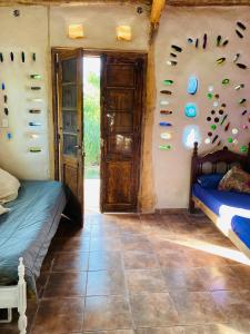 a room with two beds and shoes on the wall at Icho's mud house in Villa Icho Cruz
