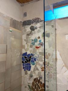a shower with stained glass mosaics on the wall at Icho's mud house in Villa Icho Cruz +9 photos