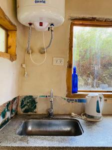 een wastafel in een keuken met een raam bij Icho's mud house in Villa Icho Cruz