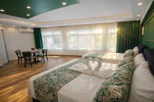 two beds in a hotel room with two swans towels at Valentina Apart Hotel in Istanbul
