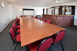 een vergaderzaal met een lange tafel en rode stoelen bij Penzión Chata Valaška in Stary Smokovec