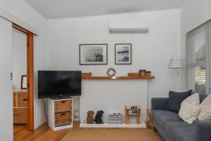 a living room with a couch and a flat screen tv at Halcyon Days in St Helens
