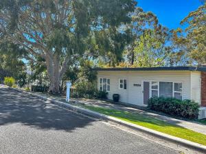 a house with a tree in front of a street at Halcyon Days in St Helens