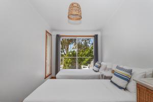 a white room with two beds and a window at Halcyon Days in St Helens