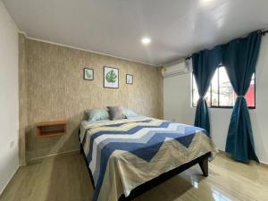 a bedroom with a bed with a blue and white comforter at Posada Kotnat in San Andrés