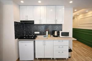 a kitchen with white cabinets and a sink and a microwave at Valentina Apart Hotel in Istanbul