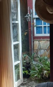 a cat sitting in front of a door at Suíte - Casa Rodante in Ouro Preto +4 photos