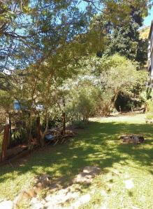a yard with a tree and a fence at Suíte - Casa Rodante in Ouro Preto